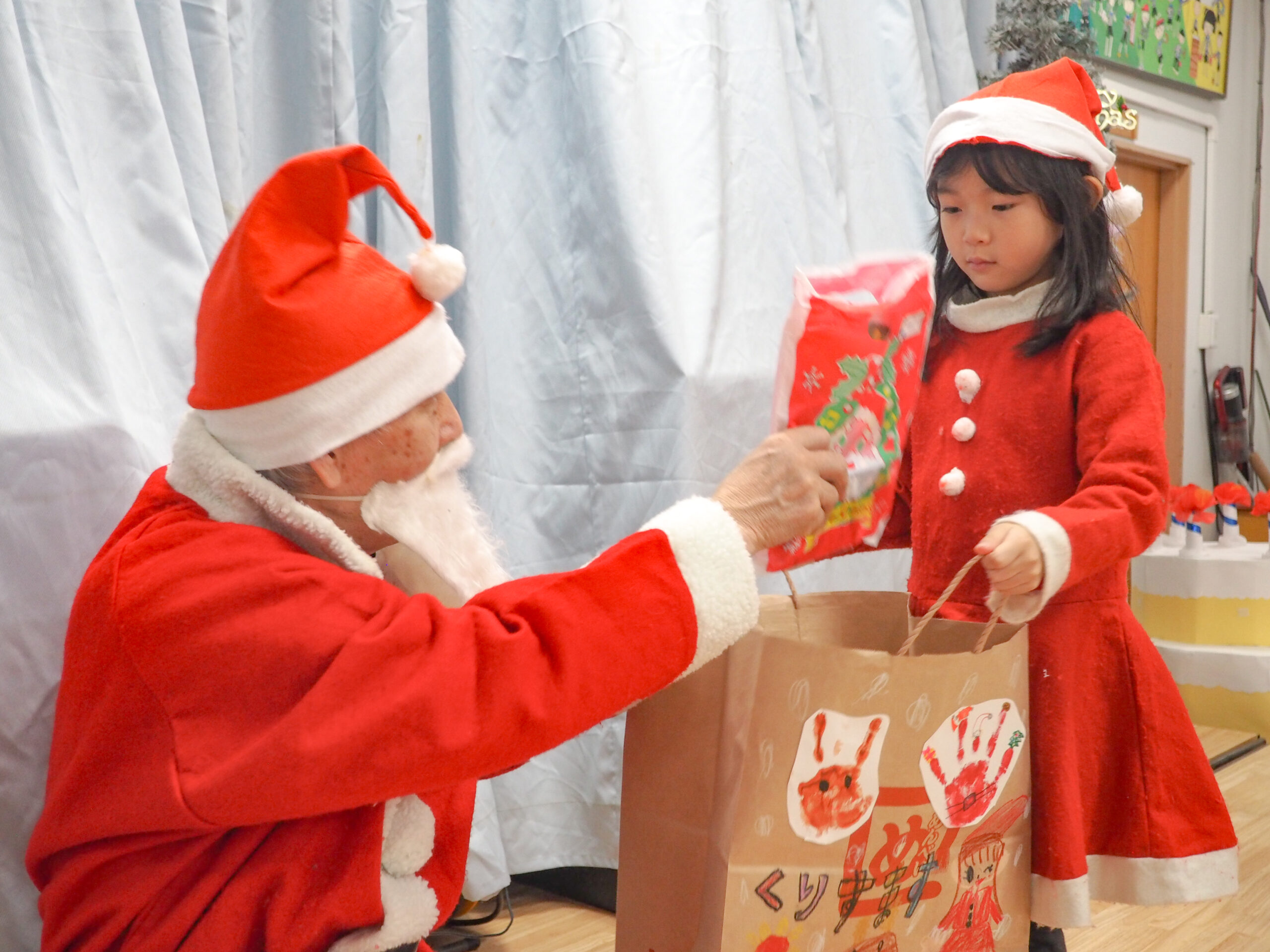 サンタさんにプレゼントをもらう園児