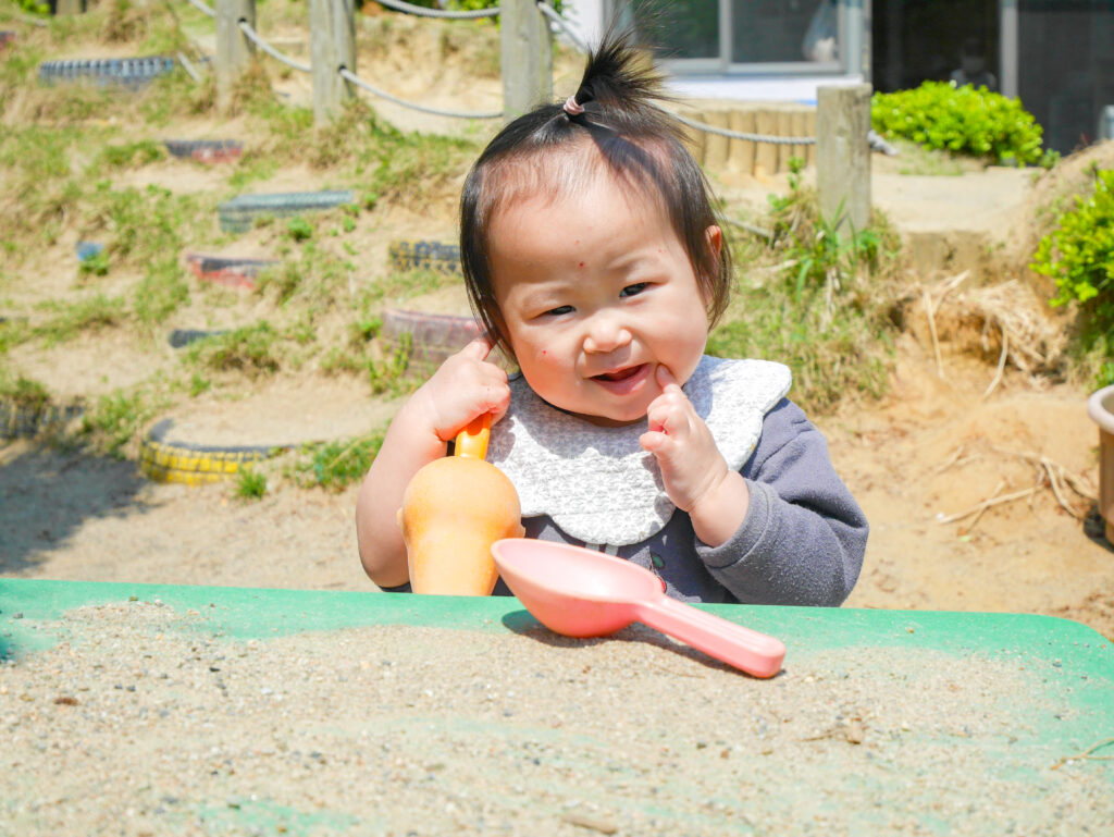 砂遊びをする園児