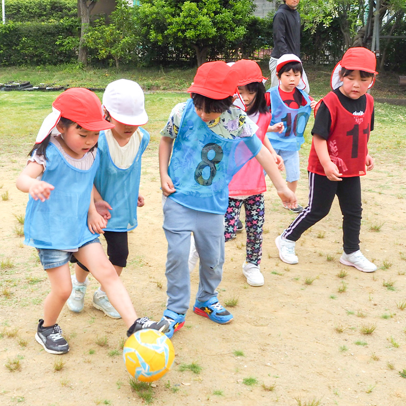 園児がサッカーをしている様子