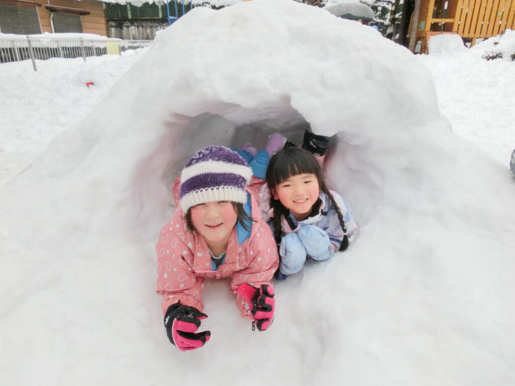 雪遊びをする園児2人