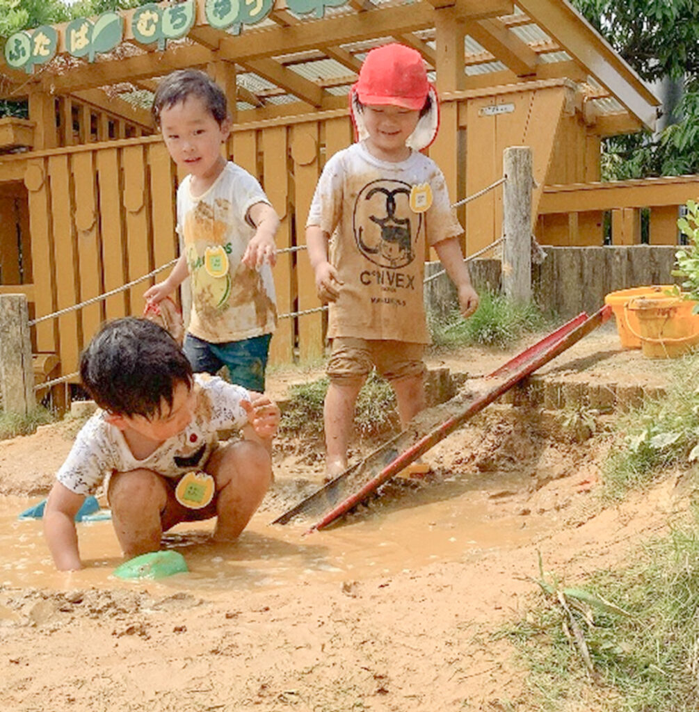 泥んこ遊びをする園児